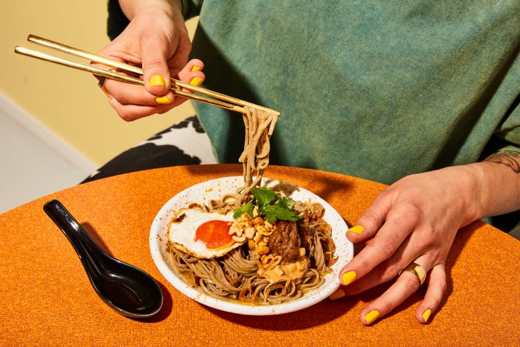 Image for food brand Future Noodles showing a person eating a dish of noodles
