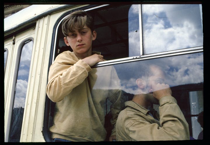 Photograph of a young person leaning out of a train window from Robin Graubard book Road to Nowhere