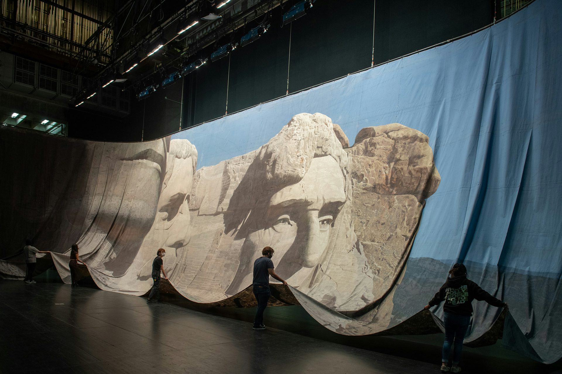 Photograph of people unravelling a backdrop of Mount Rushmore used in the movie North by Northwest