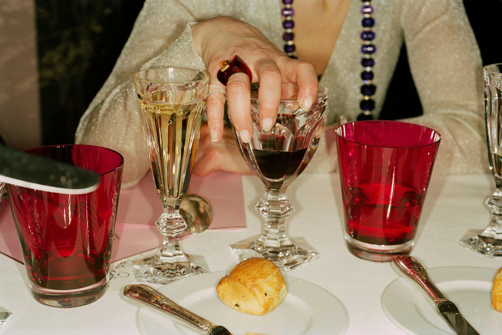 Photograph of a decorated dining table and a person holding a wine glass by Magnum photographer Martin Parr
