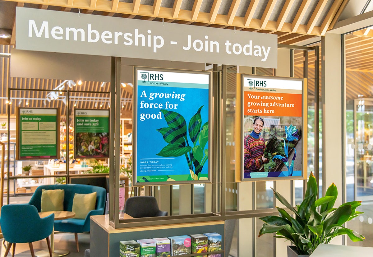 Photograph of an RHS membership desk and new posters featuring the new visual identity by Design Bridge