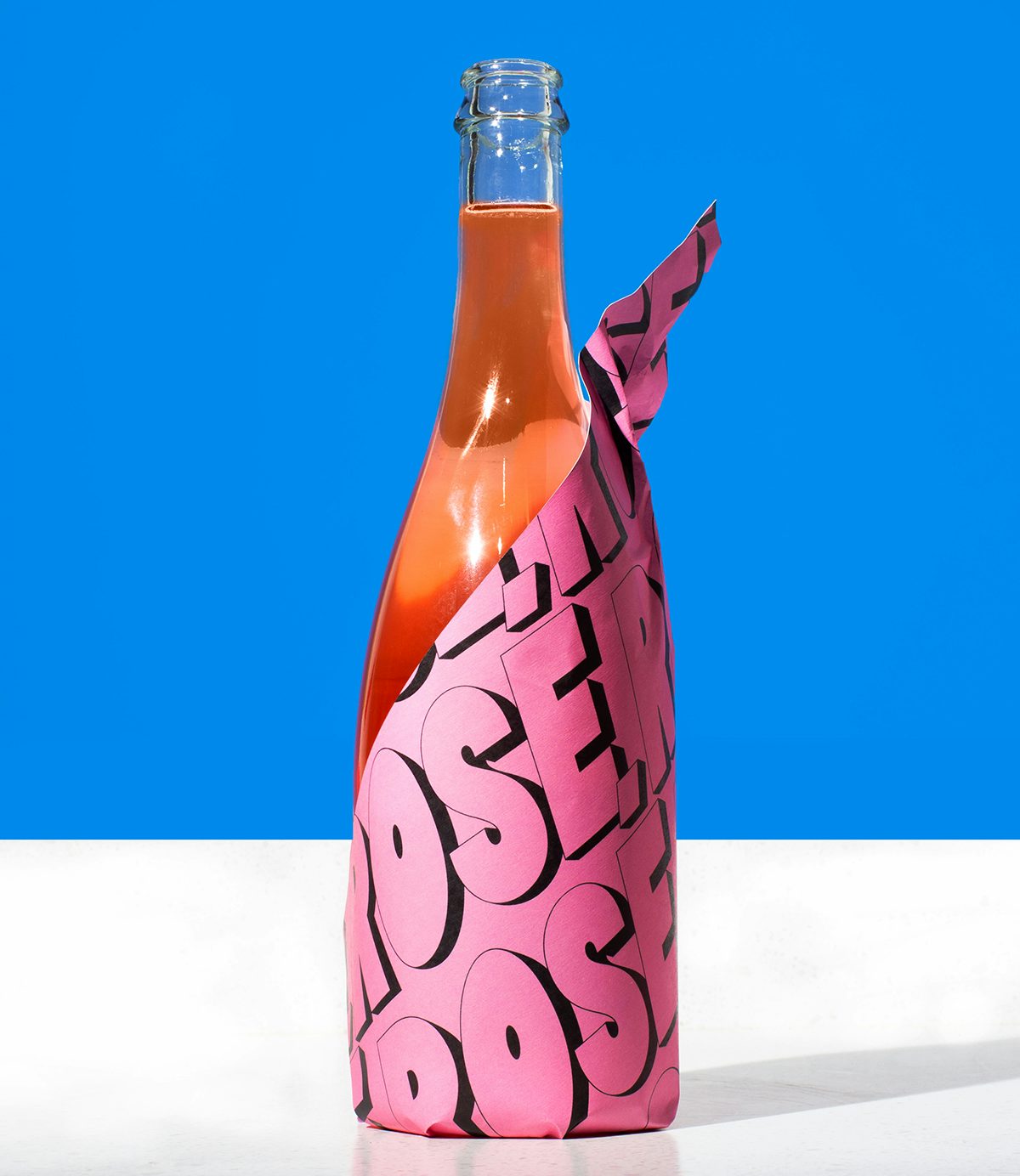 Photograph of a bottle of rosé wine, part of Stompy's branding by &Walsh