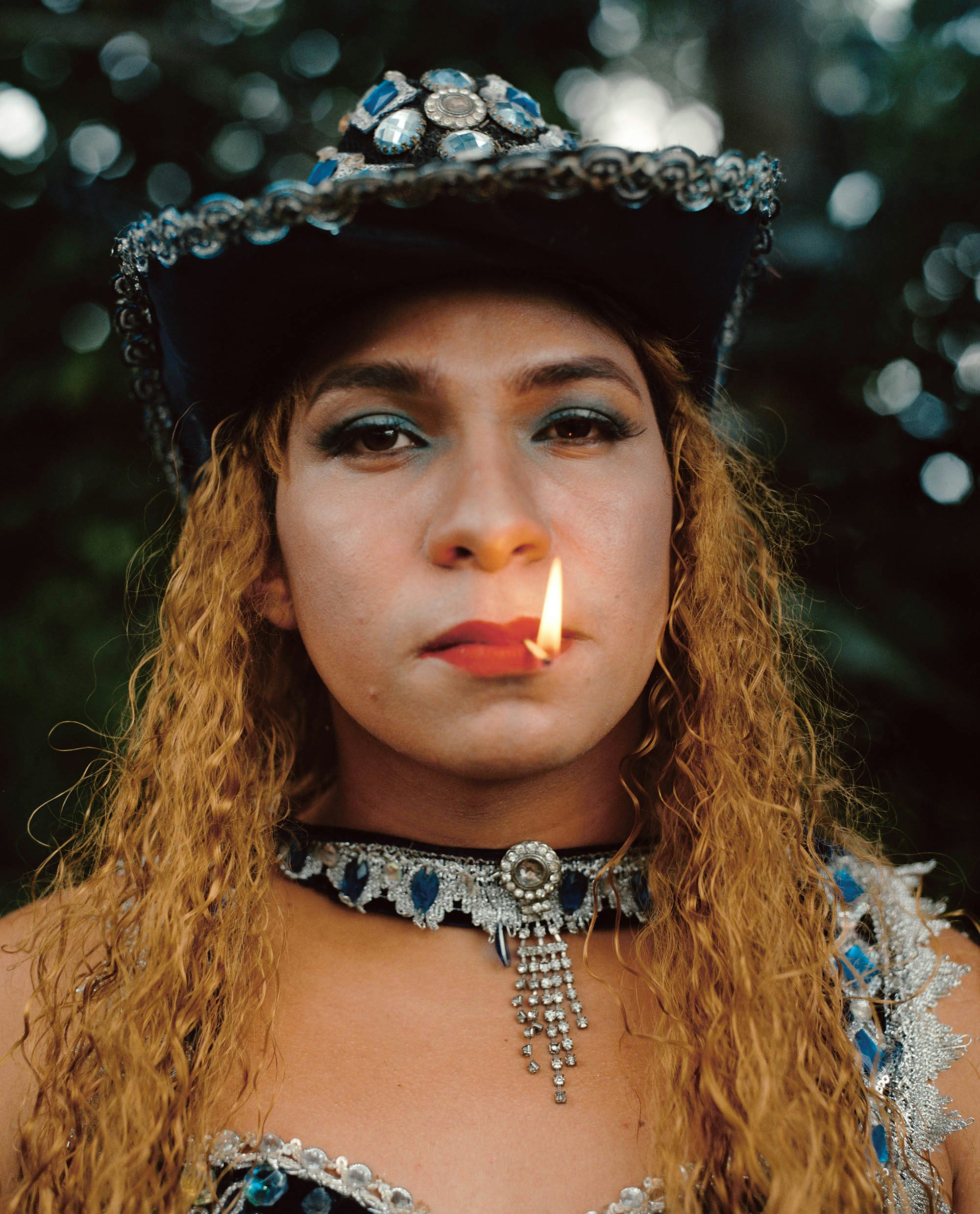 Photograph of a person smoking and wearing a jewelled hat in Like a River by Daniel Jack Lyons