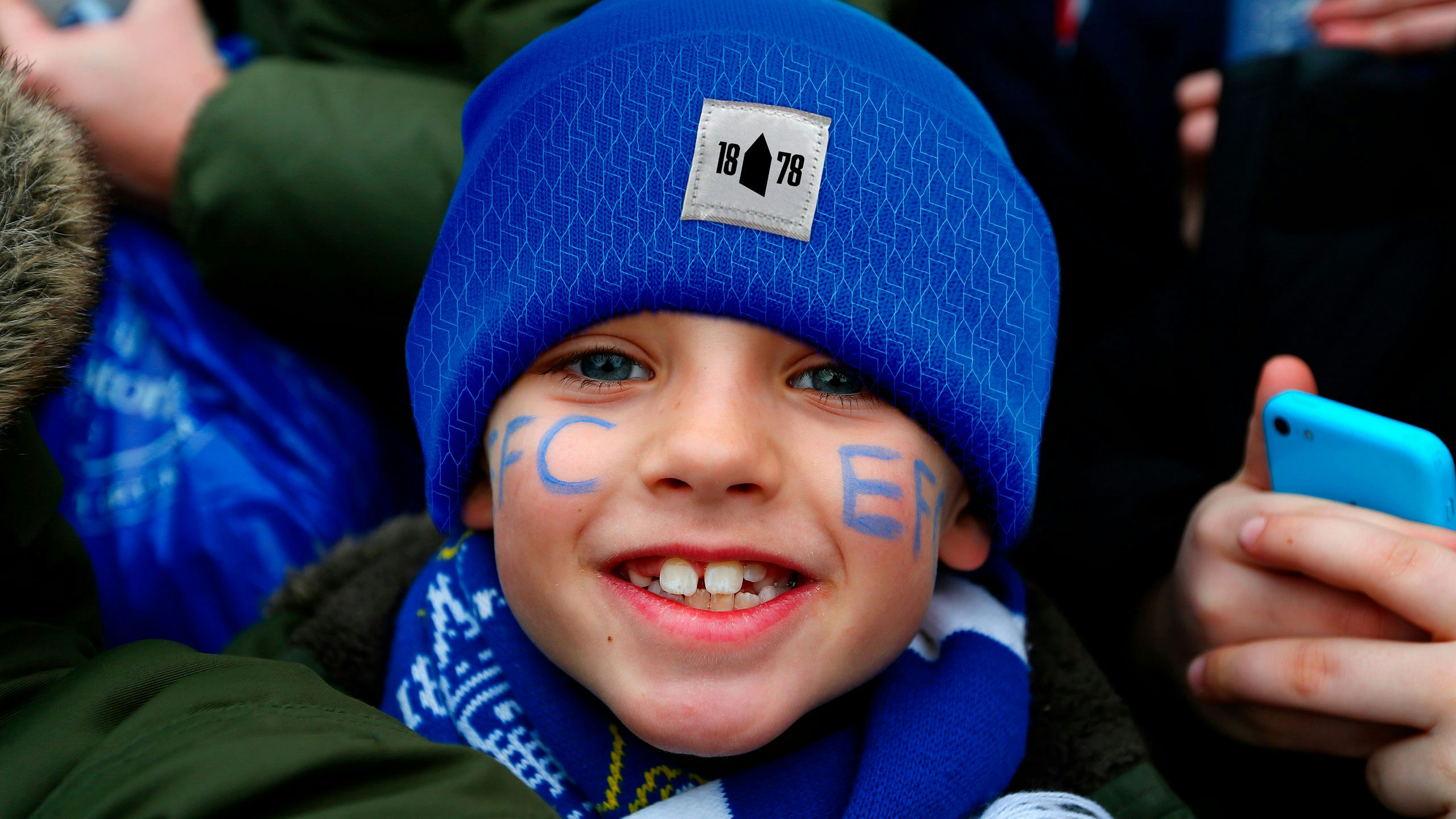 Photograph of a child wearing an blue Everton hat featuring the club's angular icon