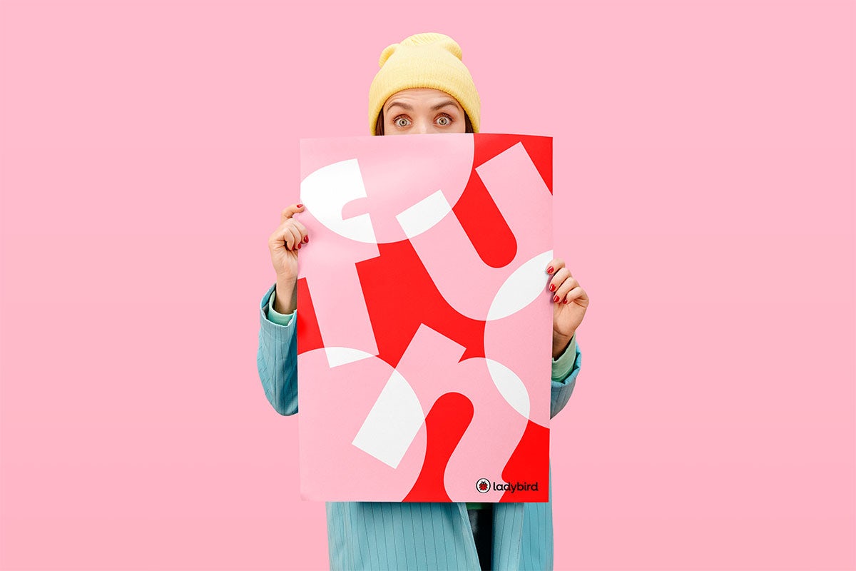 Woman holding pink and red Ladybird poster