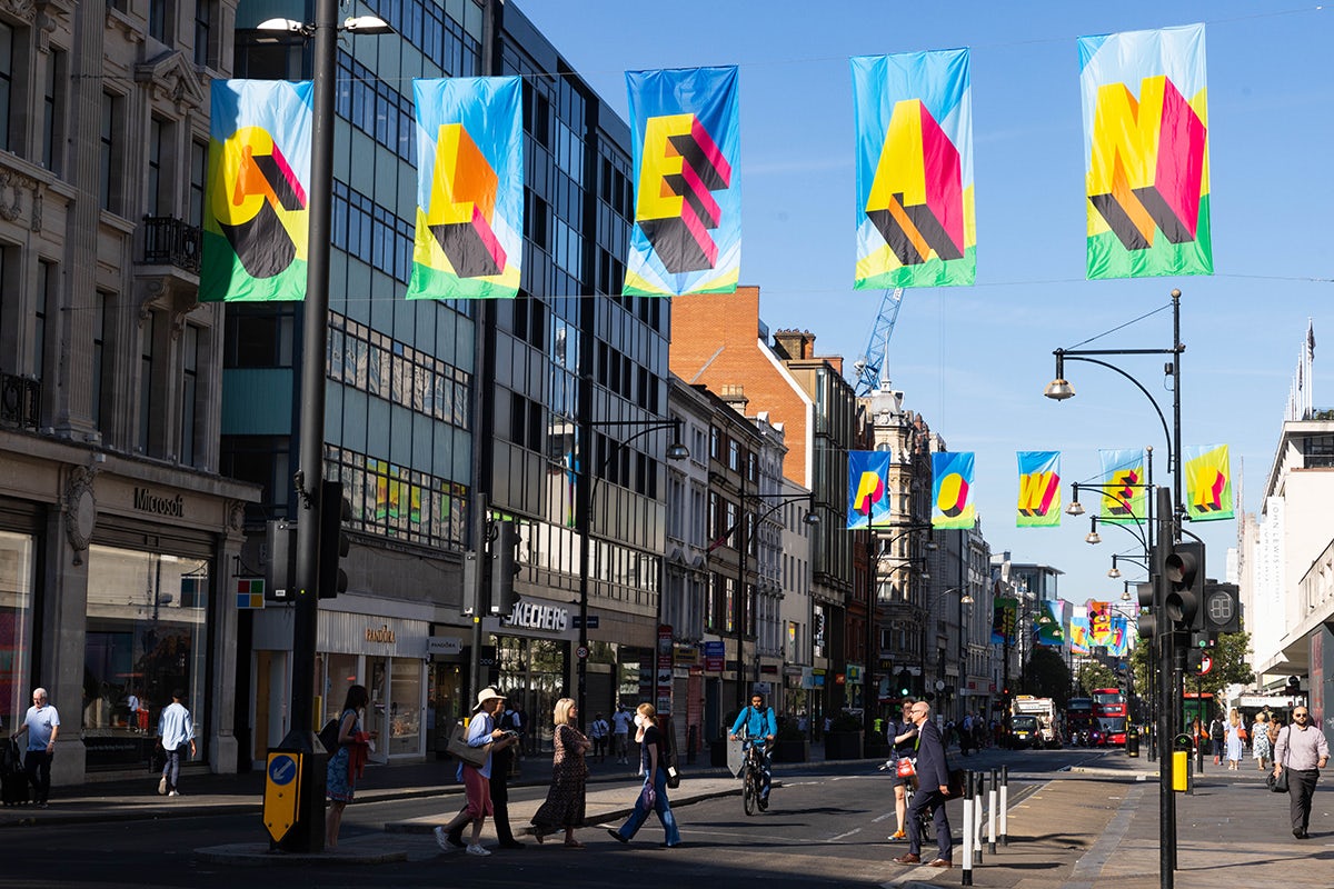 Photographie de l'installation de Morag Myerscough sur Oxford Street, avec des drapeaux colorés sur lesquels on peut lire
