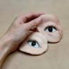 Image by Aneta Grzeszykowska showing a hand holding two cut-outs of eyes