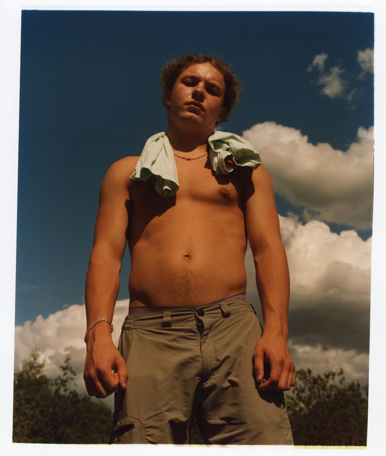 Photograph by Niall Hodson of a young person with their shirt slung over their shoulders