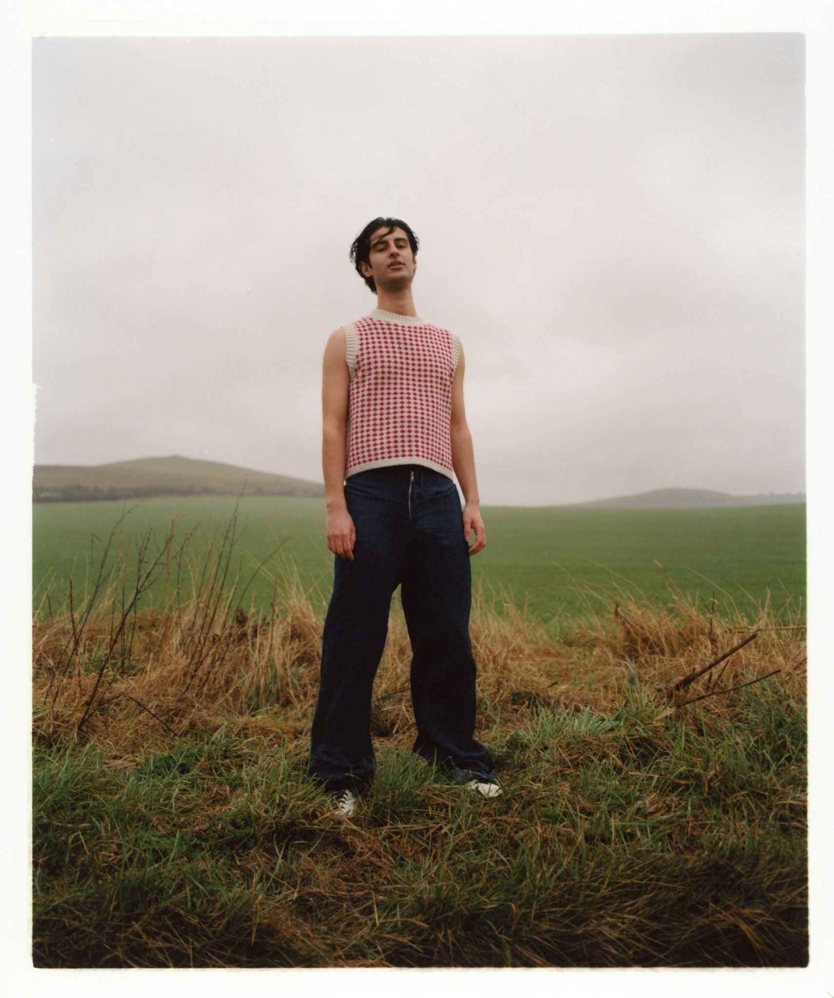 Photograph by Niall Hodson of a person wearing a red and white knitted sweater in a field
