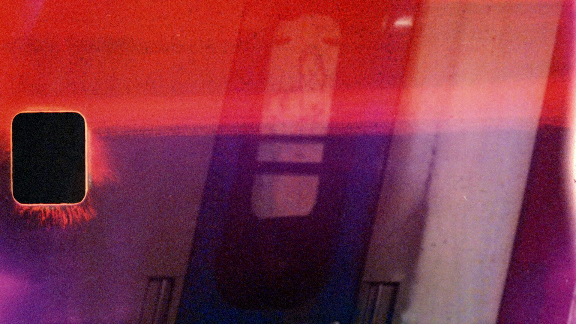 Still abstract image of a pink reflection of a train carriage from the music video for ATK by Bonobo