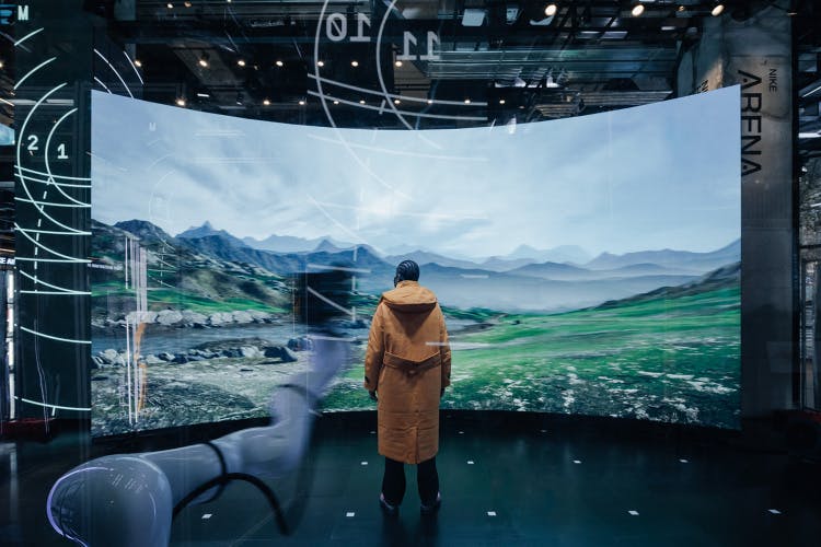 Photograph showing a person stood in front of a landscape installation in the multi-sensory weather dome created by Modem for Nike at the House of Innovation