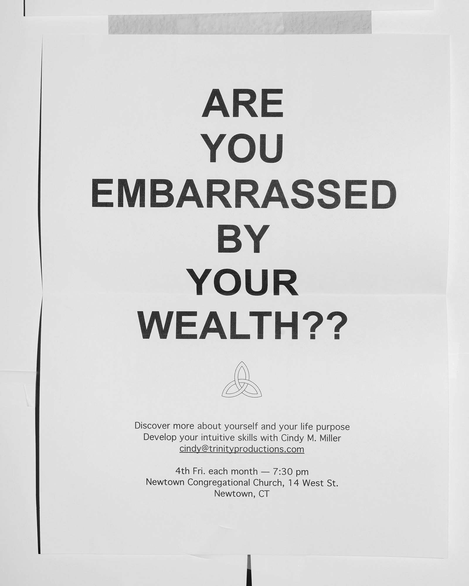 Photograph shows a poster that reads 'Are you embarrassed by your wealth?', in the Four Pillars book by Eli Durst