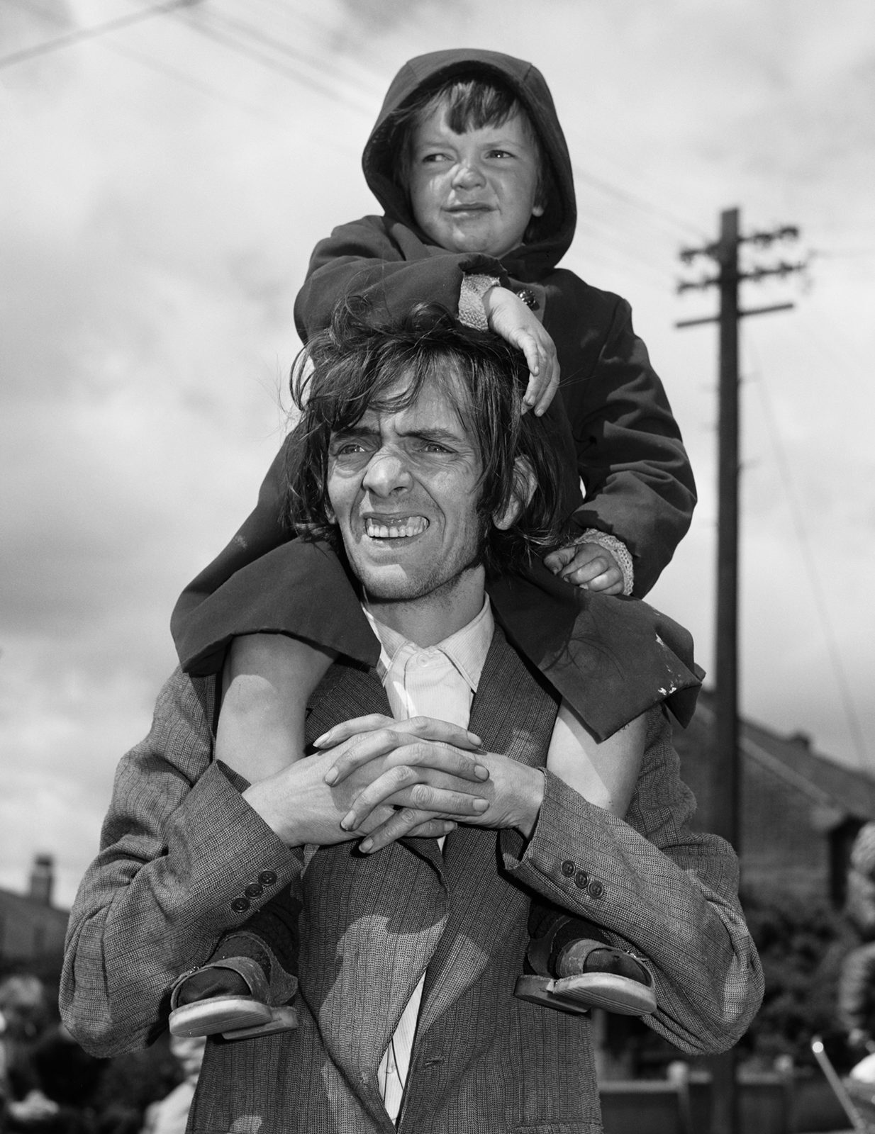 Black and white photograph of a father carrying his son on his shoulders, which appears in the new Chris Killip exhibition