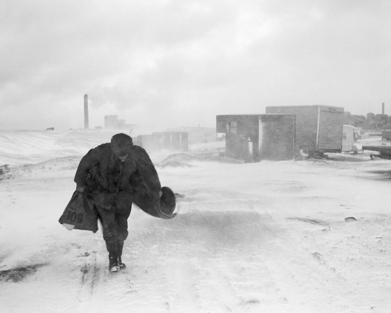 Black and white photograph of a person marching through the snow, which appears in the new Chris Killip exhibition