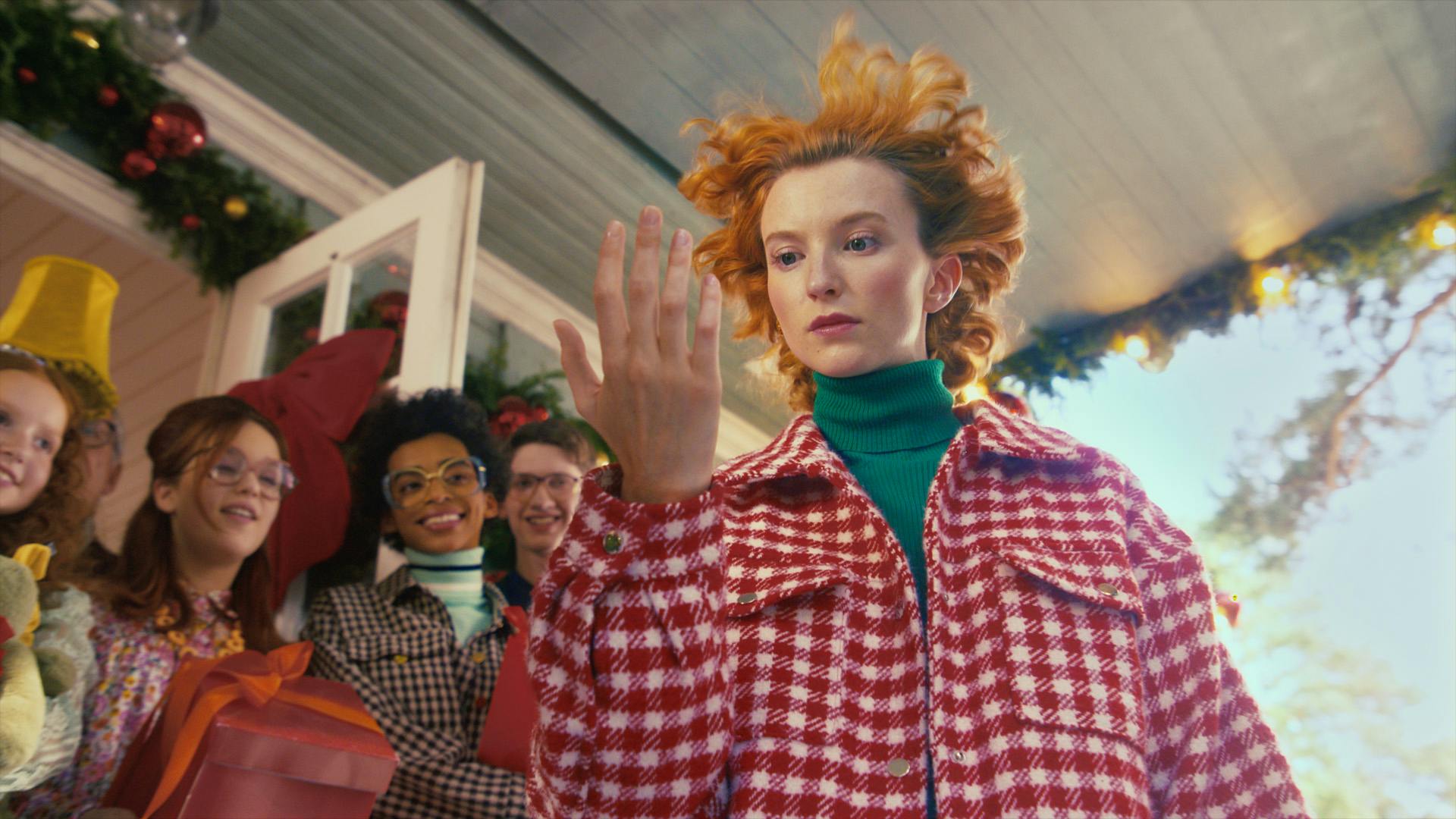 Image shows a woman in a red checkered jacket staring at her hand, in the TK Maxx Christmas 2022 advert