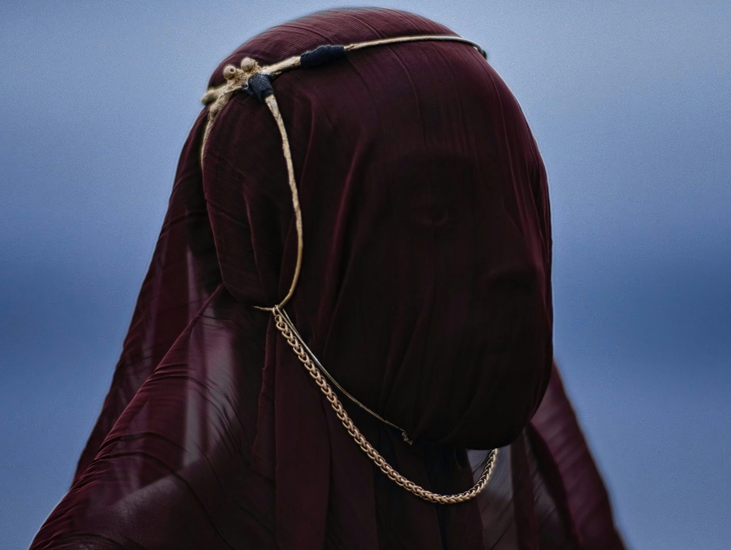 Still image of a person wearing a red headdress in the music video for I Saw by Young Fathers