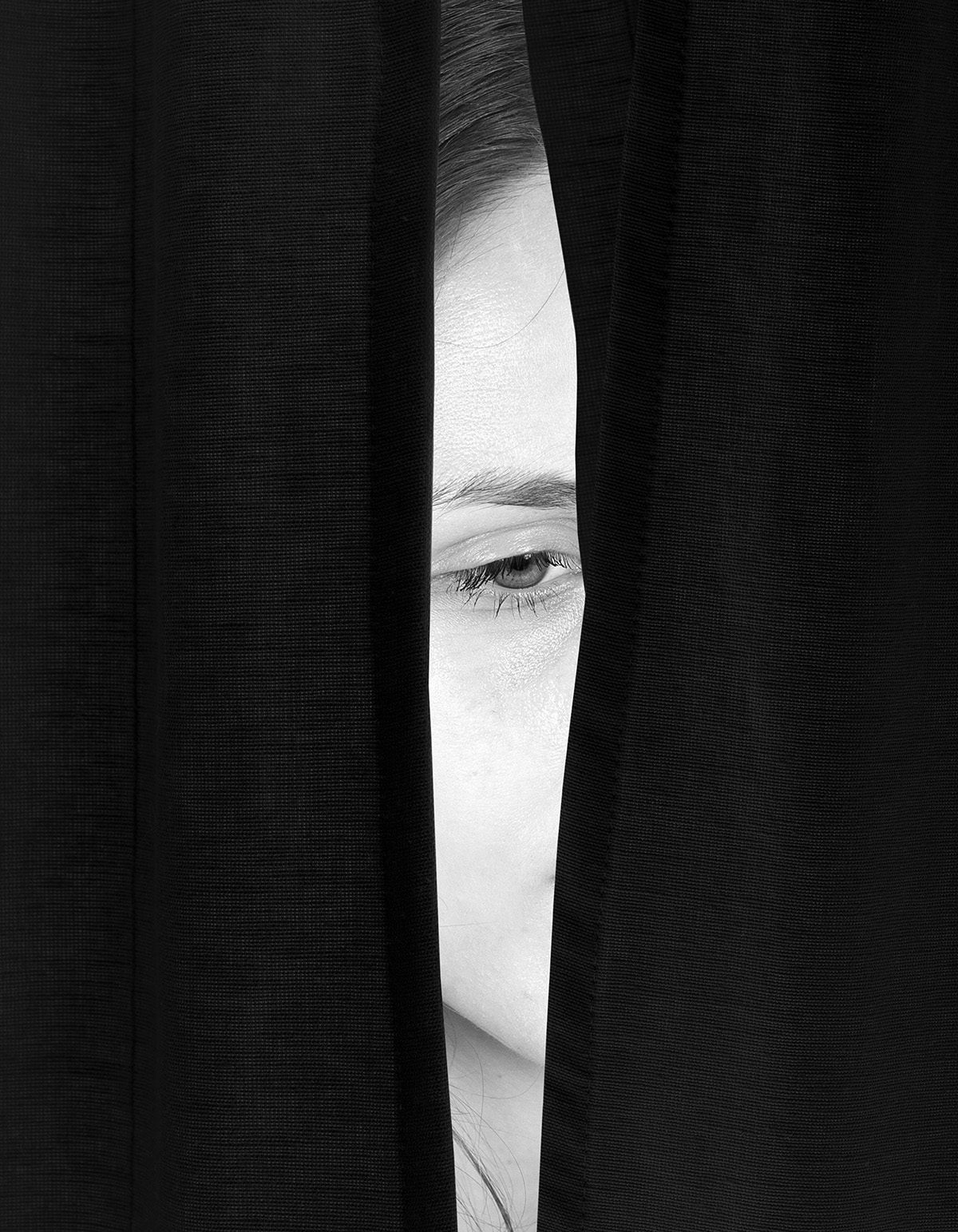Image by Brea Souders for the New York Times shows a sliver of a woman's face visible through a cloak of black material
