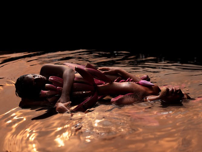 Image by David Uzochukwu shows two figures lying in water with the characteristics of a sea creature