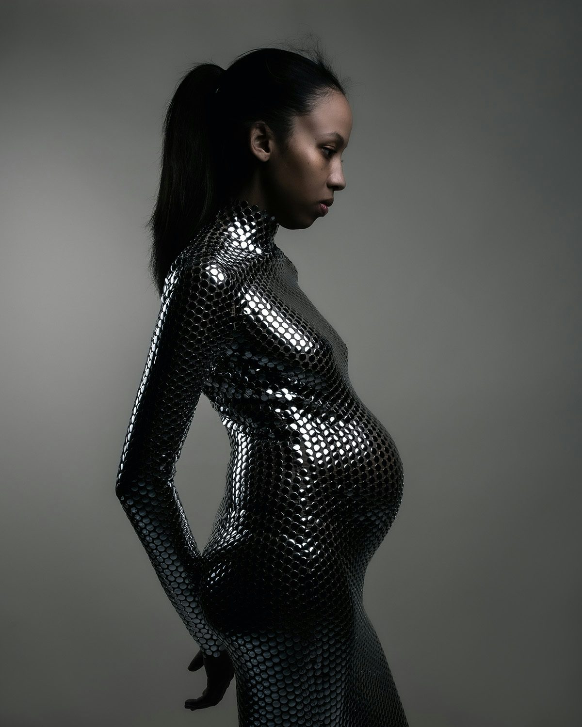 Image by Jet Swan showing a woman with a baby bump wearing a tight, glittery outfit