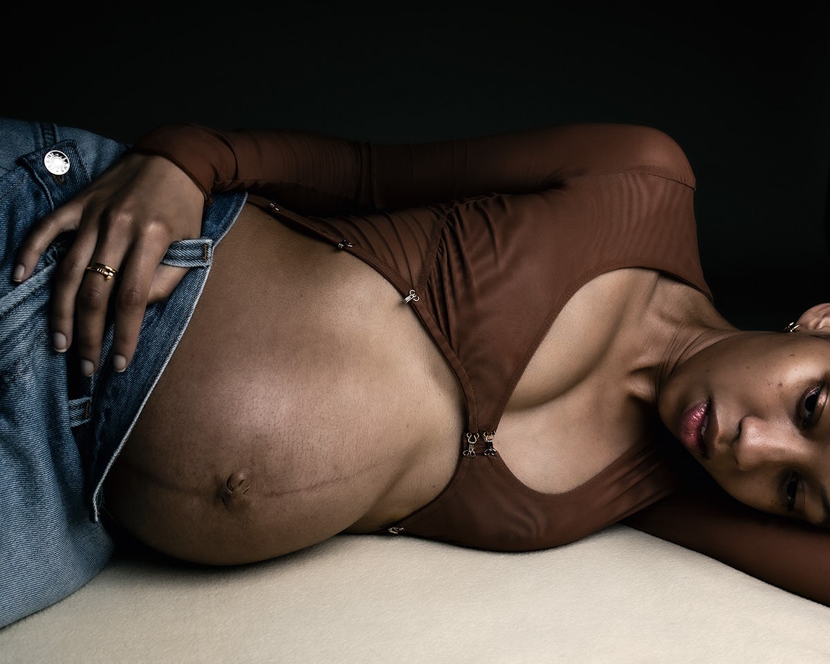 Image by Jet Swan showing a woman with a baby bump lying on her side and baring her stomach