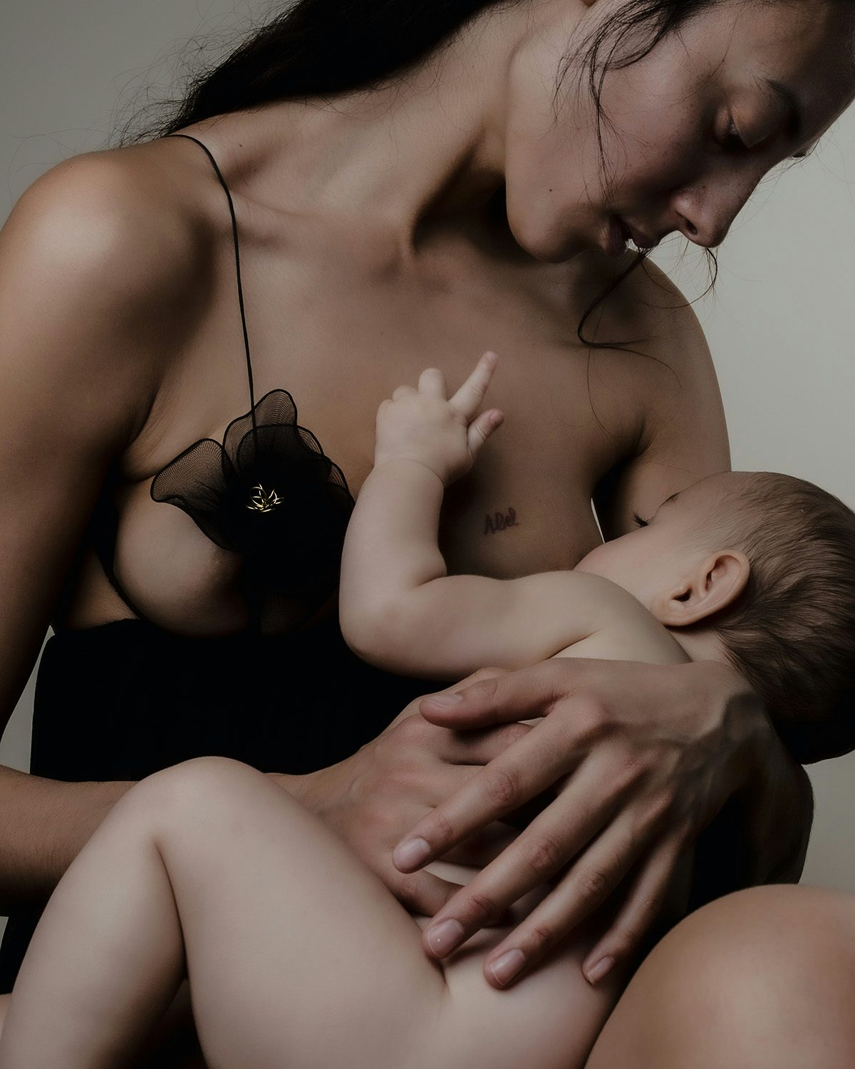 Image by Jet Swan shows a mother wearing a strappy dress as she breastfeeds her child