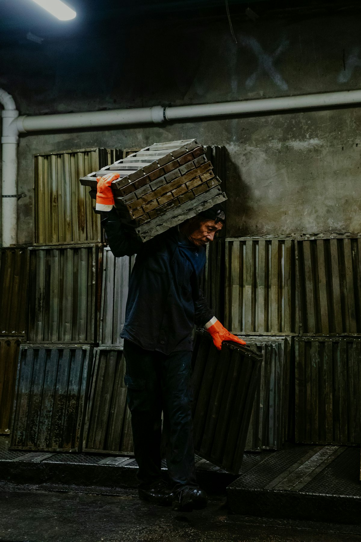 Image by Justin J Wee showing Mr Gao carrying clean oil grates at his job
