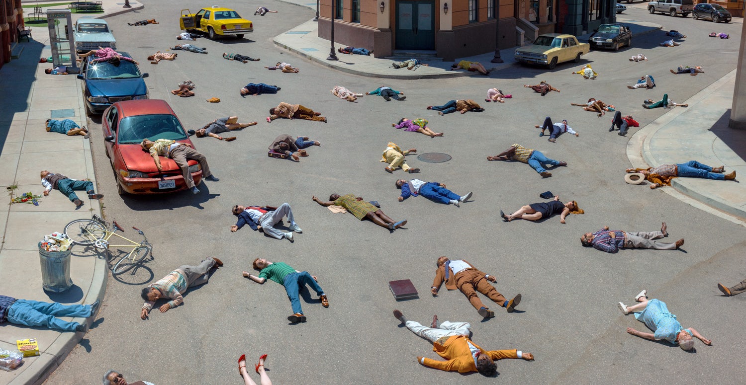 Alex Prager's image shows a suburban street covered with human bodies lying evenly spaced on the ground