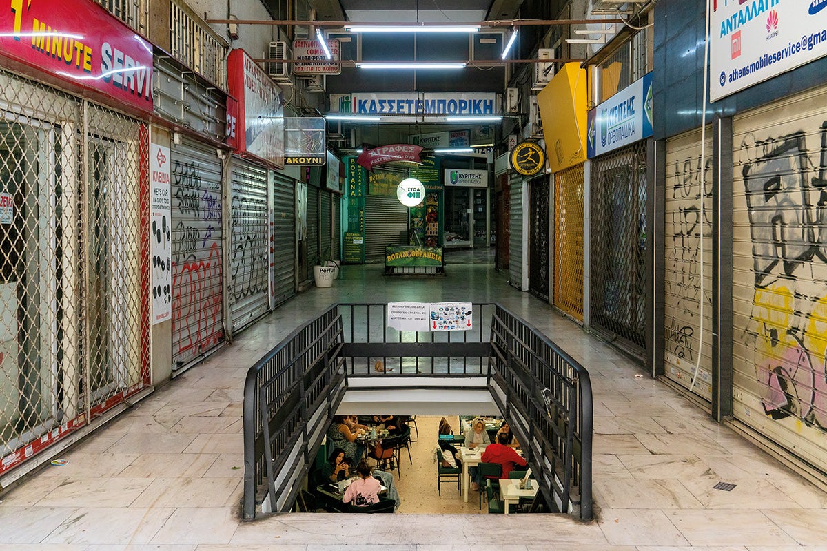 Image by Niko J. Kallianiotis showing the inside of an empty shopping mall and a glimpse of the underground seated space beneath it