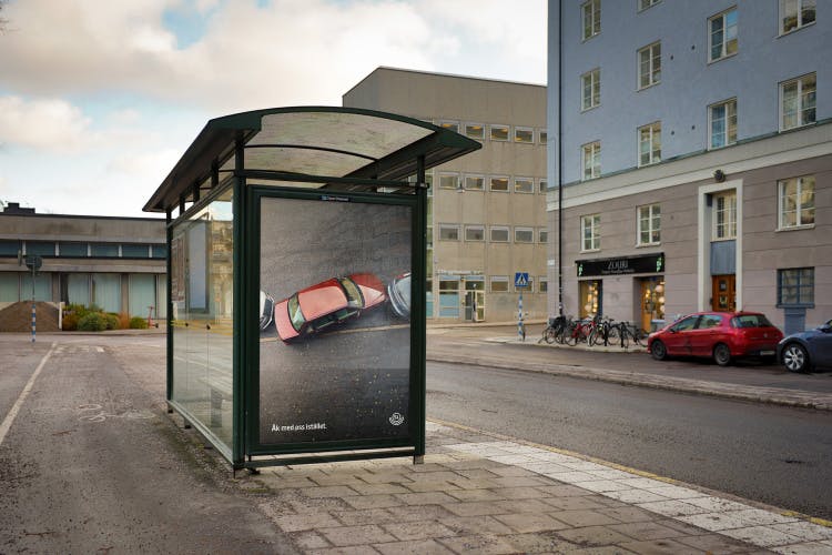 Image shows an outdoor advert for Stockholm public transport network SL, which shows an aerial photo of a red car trying to get out of a tight parallel parking space