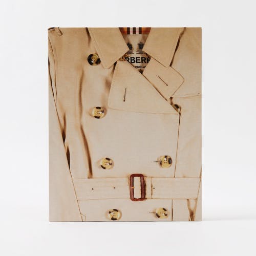 Image shows the cover of the new Burberry book, featuring a cropped image of its trench coat