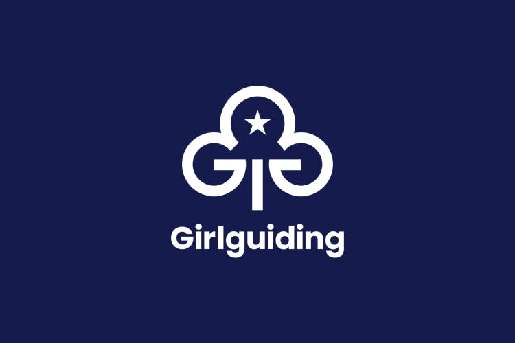 Graphic shows the new Girlguiding branding featuring a white tree emblem on a dark blue background