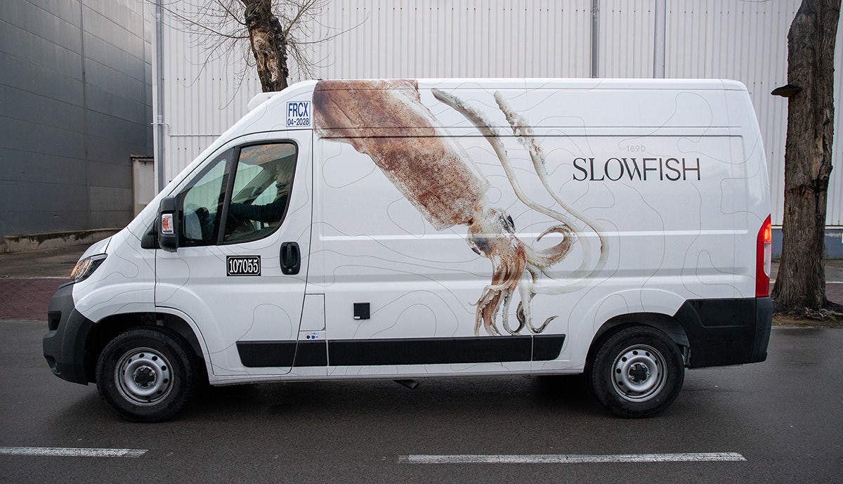Image shows a van covered in Slowfish branding by Vasava featuring an illustration of a squid