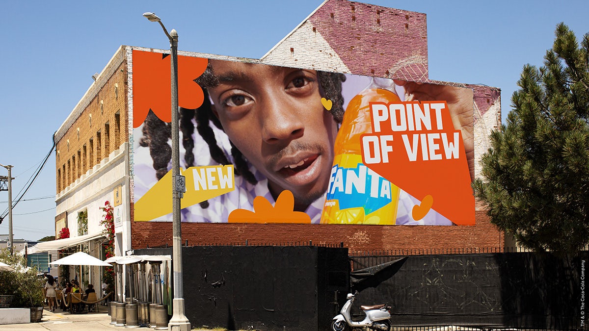 Image shows an advertisement featuring the new Fanta branding which reads 'New point of view' in colourful letters next to a photograph of a person's face