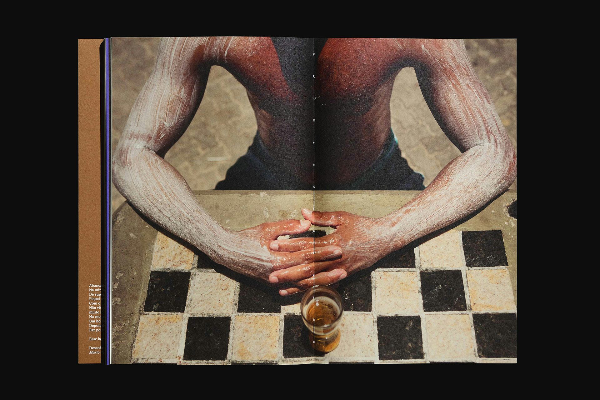 Spread from Quilo magazine showing a person with white paste covering their arms leaning on a chess table