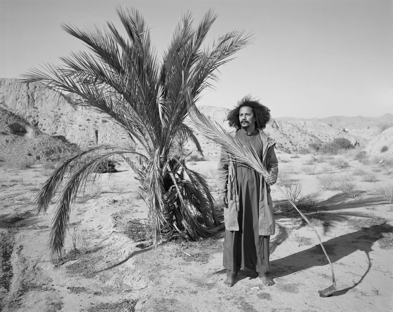 Black and white photograph of a person stood in a desert environment, featured in the Sony World Photo Awards 2023