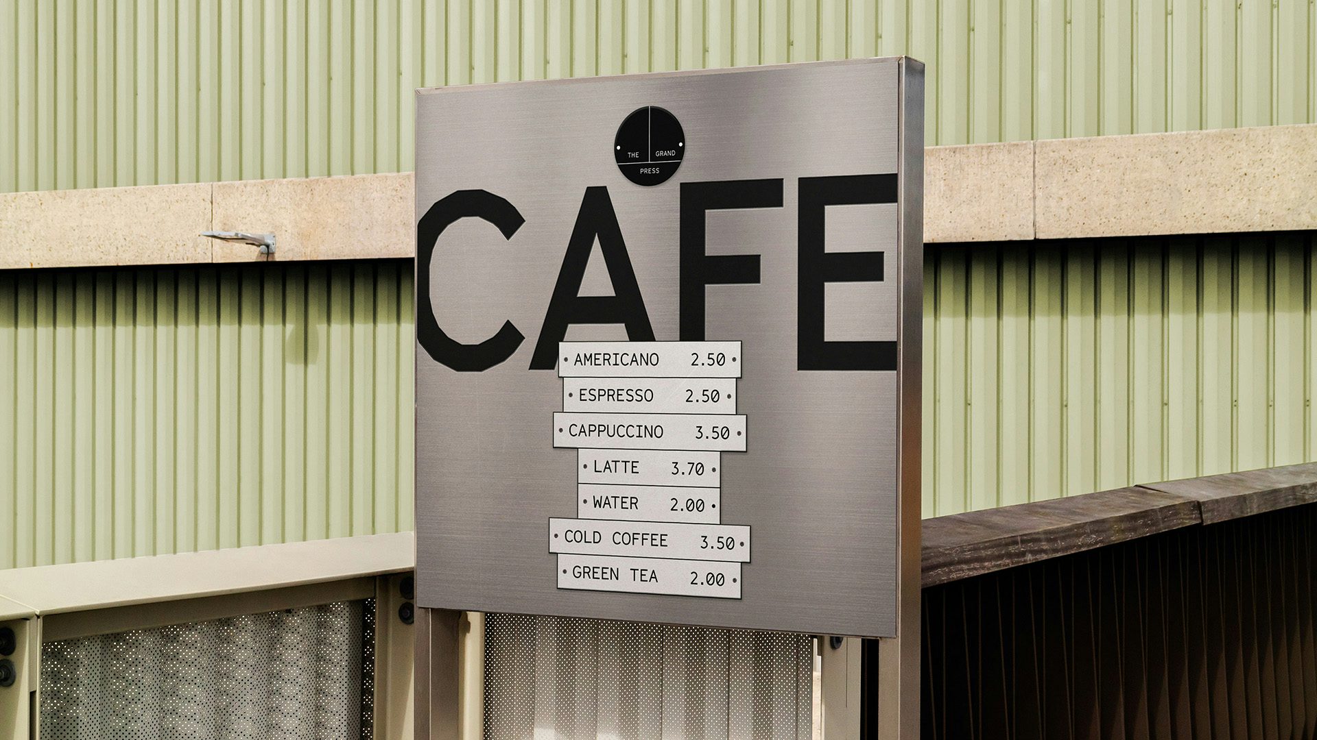 Image shows a menu for the Grand Press cafe featuring a price list on a grey background