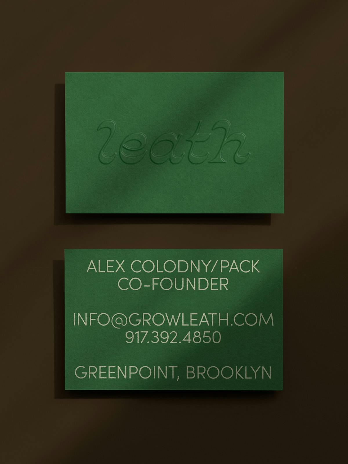 Image showing the branding for Leath, as seen on dark green business cards with the brand name inscribed in elaborate lettering on the top card, and contact details for co-founder Alex Colodny on the bottom card