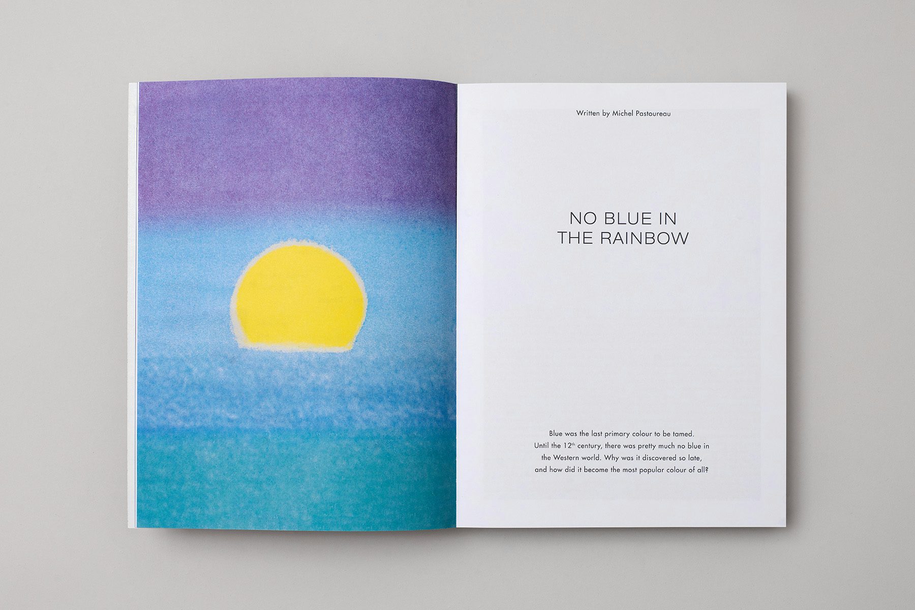 Photograph of a spread from the Blue issue of The Colour Journal, showing a print by Andy Warhol of a yellow sun dipping into blue waters on the left hand page, and text on the right hand page headlined 'No blue in the rainbow'