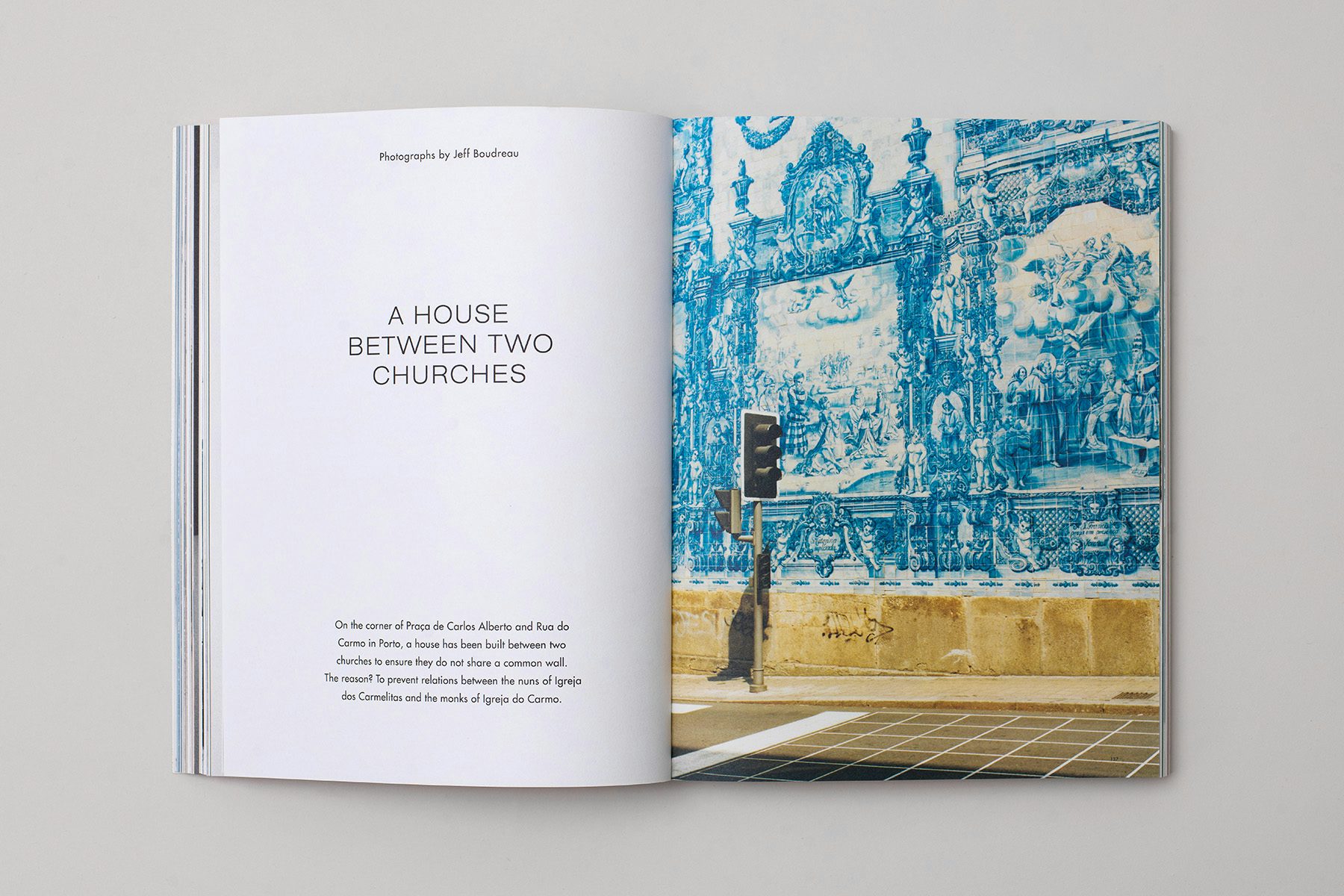 Photograph of a spread from the Blue issue of The Colour Journal, showing text on the left hand page headlined 'A house between two cities', and a photo on the right hand page of a decorative blue and white wall mural next to a traffic light