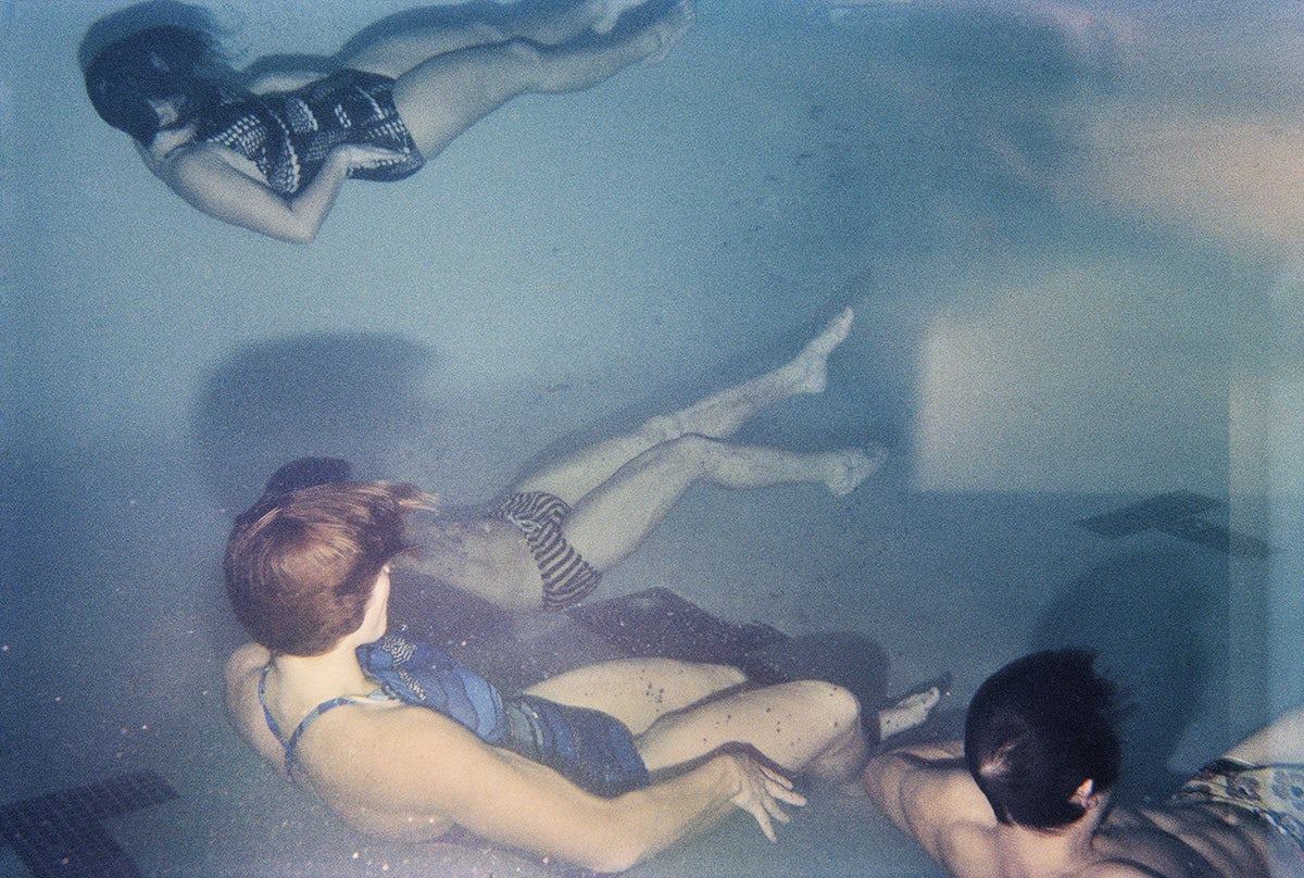 Photograph by Larry Sultan from his series Swimmers showing people wearing swimming costumes underwater in a pool appearing to lie down