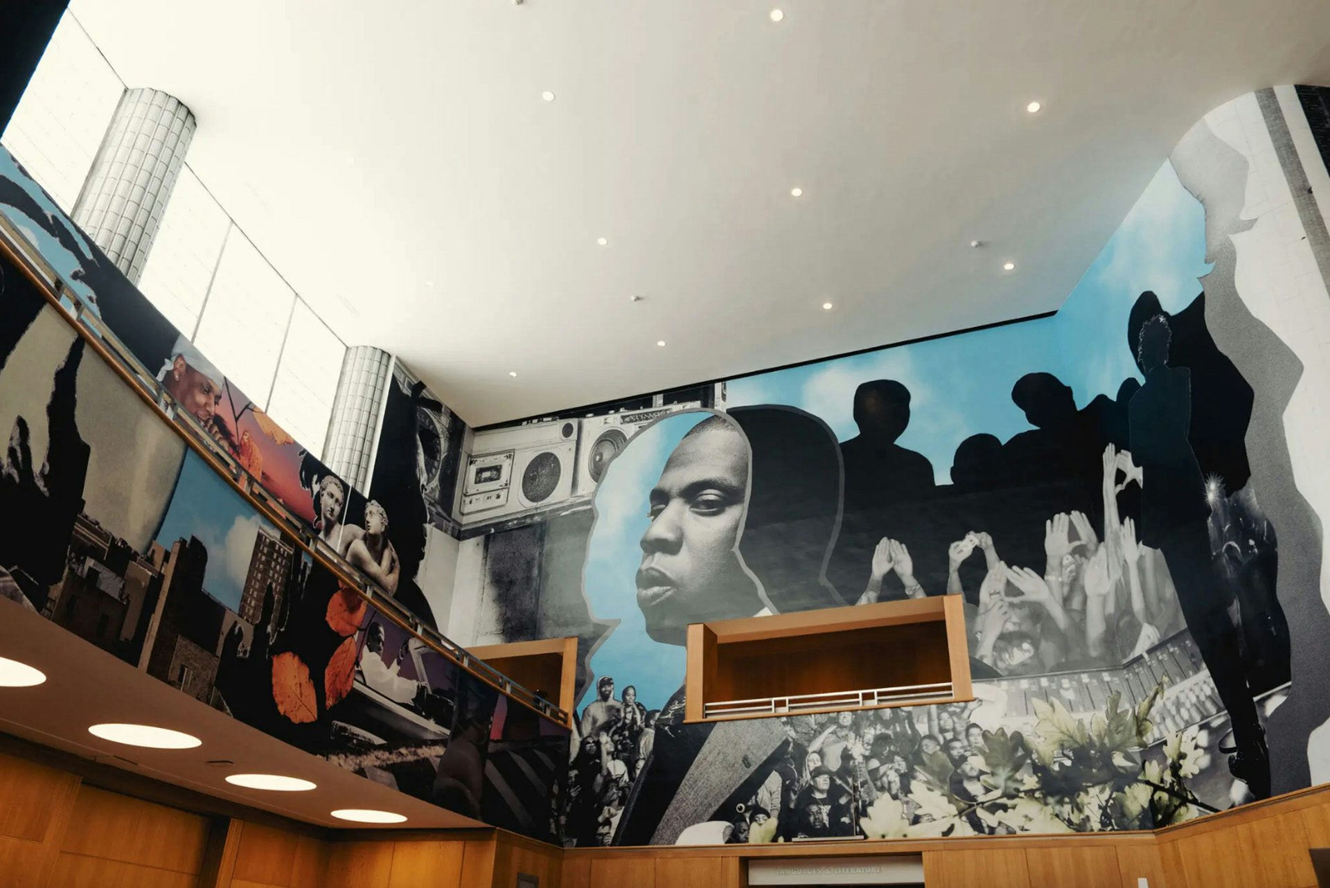 Photo of the main hall at the Brooklyn Public Library showing Jazz Grant's mural of Jay Z surrounding the upper half of the space