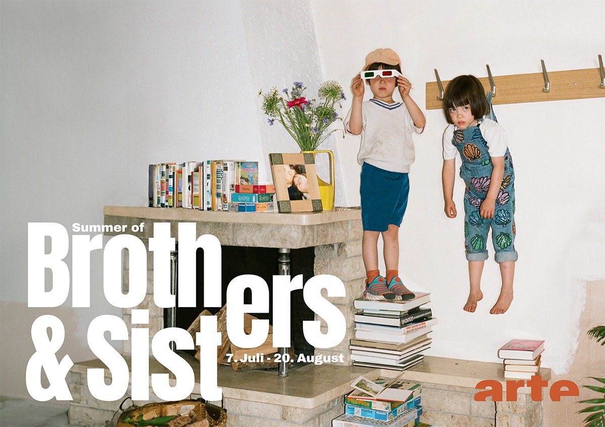 Image from Arte's Brothers and Sisters campaign, showing a photo of a child wearing sunglasses standing on a tower of books with another child with a fringe and dungarees hanging from a coat hook. The letters 'er' are split between the words 'Brothers' and 'Sisters'