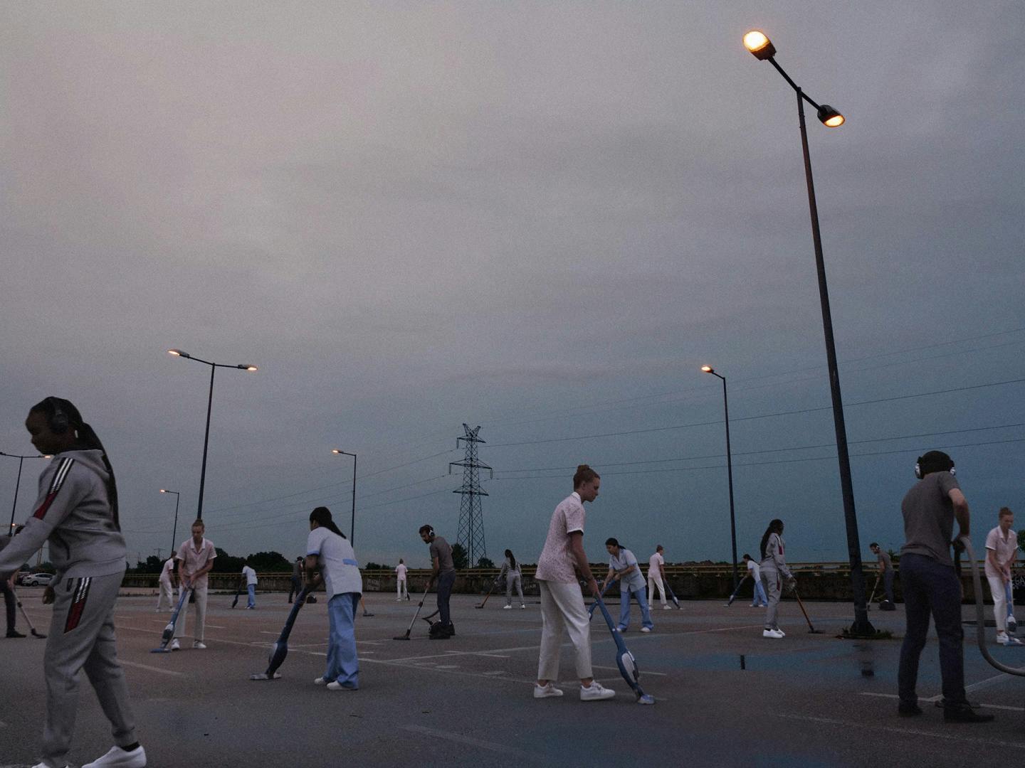 Still from the music video for Schwer by Paul Kalkbrenner showing visualisations of people walking around a car park at dusk appearing to hold metal detectors