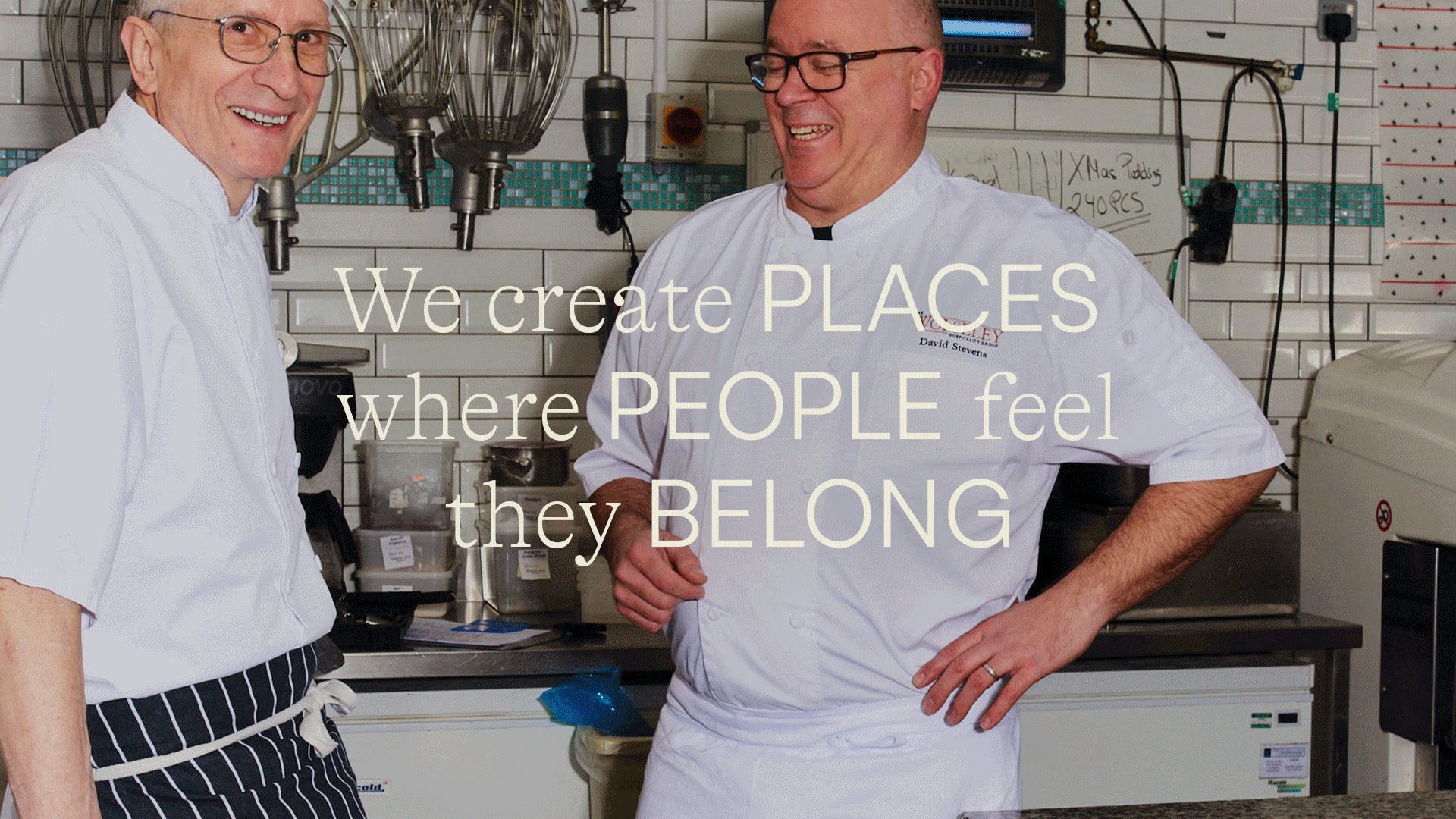 Image from the Wolseley's new digital identity, showing a photo of two chefs in a kitchen and the headline 'We create places where people feel they belong' layered over the top in white serif and sans-serif fonts