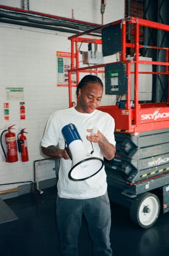 Photo of Raheem Sterling holding a mega phona