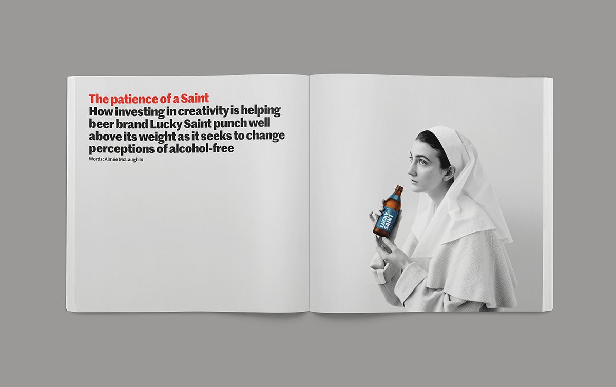Image shows a spread from the Creative Review Creative Leaders 2023 issue, showing text on the left hand page and a photograph of a saint appearing to hold a bottle of Lucky Saint on the right hand page