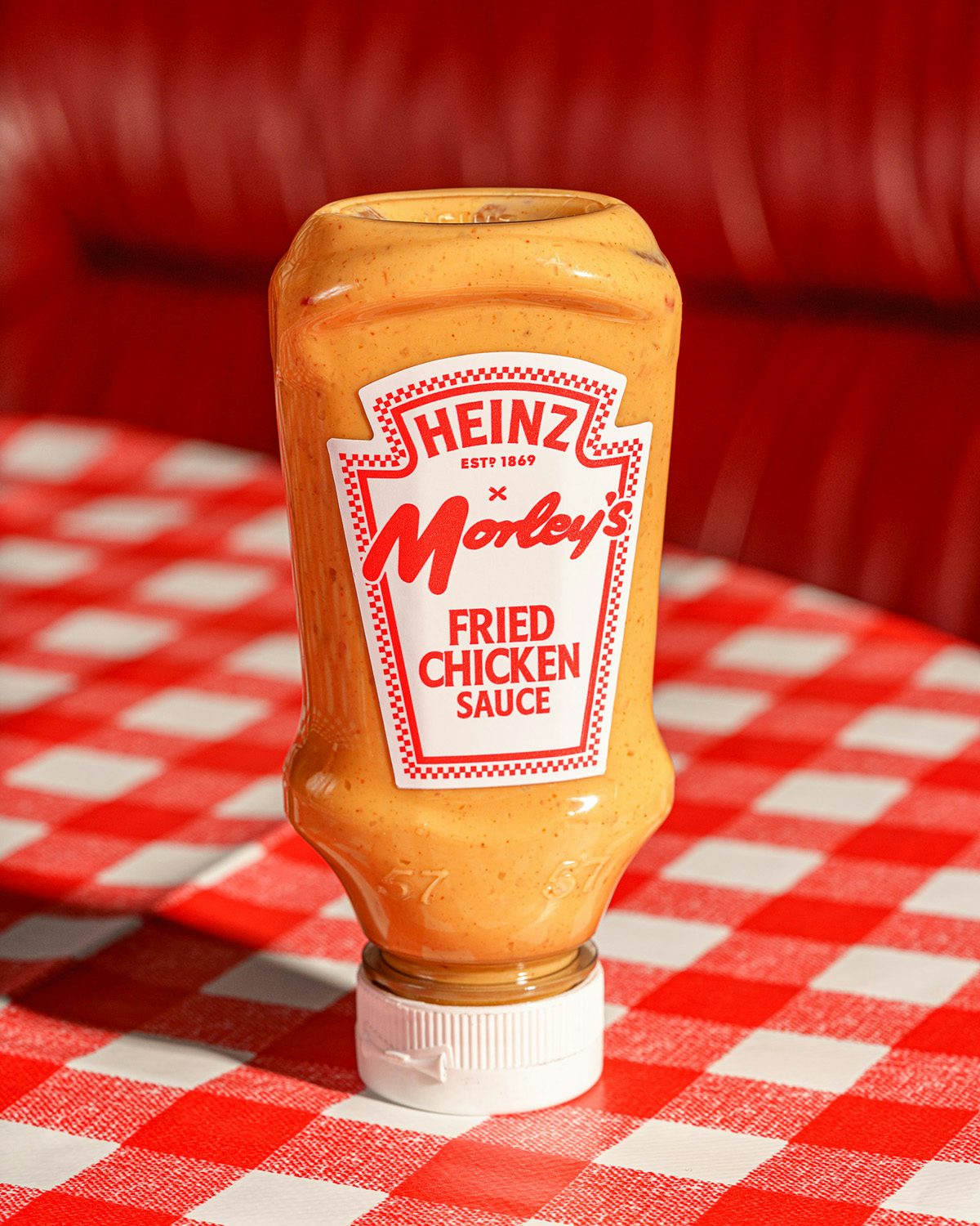 Photograph of a squeezy bottle of Heinz and Morley's Fried Chicken Sauce on a red gingham tablecloth