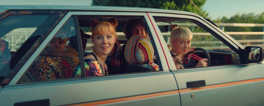 Still from McDonald's Raise Your Arches campaign film showing four young people looking out from a grey car