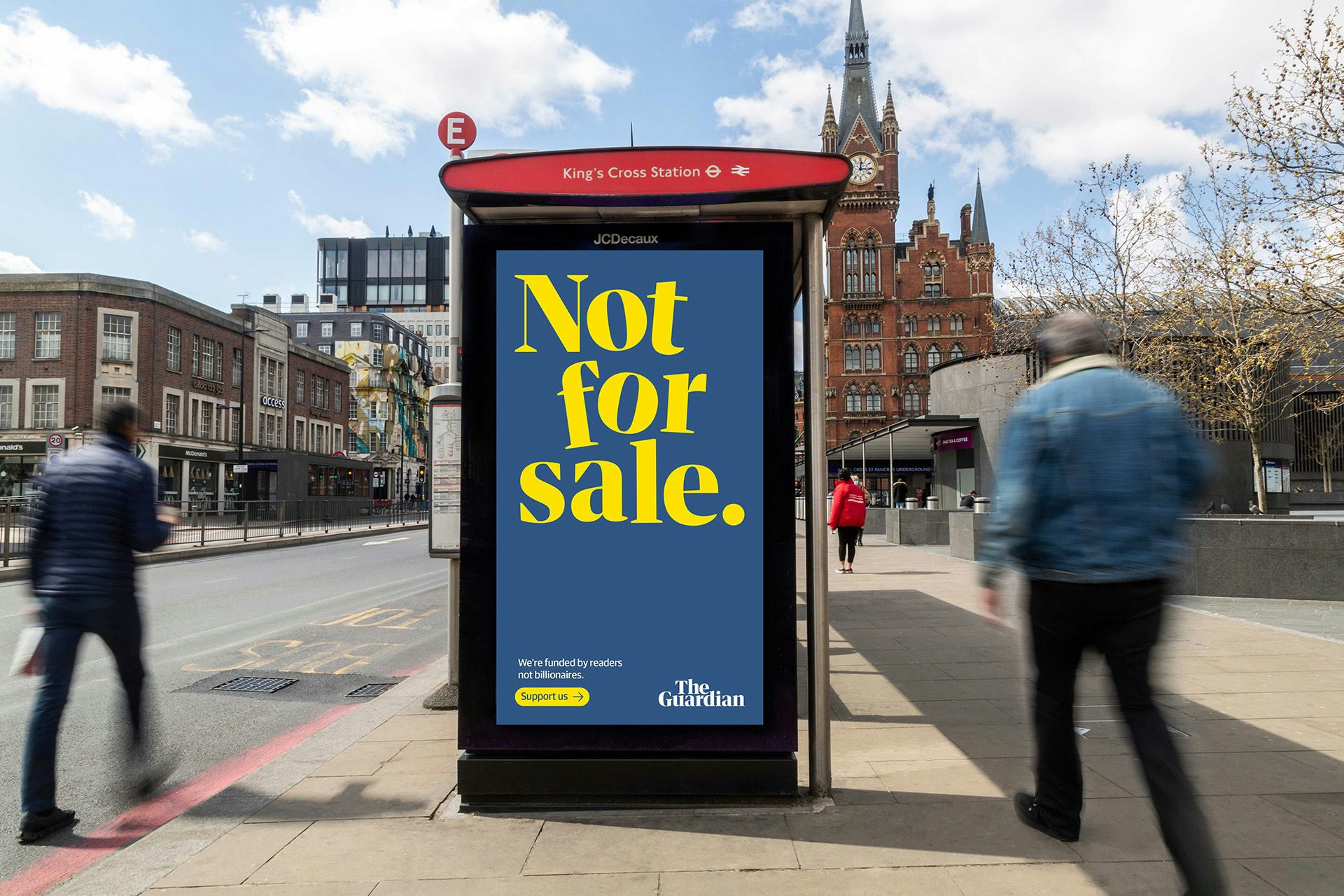 Photo of a vertical outdoor poster headlined 'Not for sale' in slightly wonky yellow letters on a blue background, shown on a bus stop in front of King's Cross Station created as part of the Guardian's new brand campaign