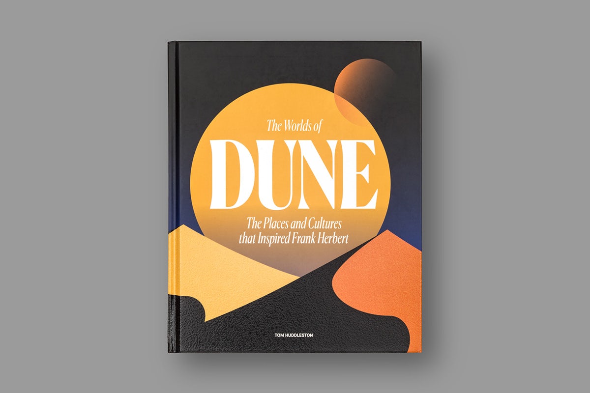 Image of the front cover of a book about Dune, featuring minimal illustrations representing sand dunes, and a large planet-like circle looming over the top